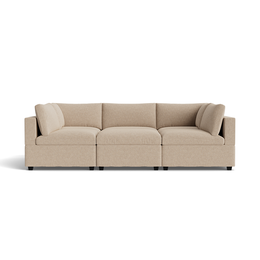 The Kova Box Cushion Pit is a beige three-seat sectional sofa with low arms and backrest, upholstered in textured fabric and shown against a plain black background.