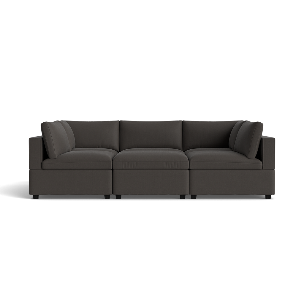 The Kova Box Cushion Pit is a modern, dark gray sectional sofa featuring three connected seats, plush back cushions, and wide armrests, shown from the front on a transparent background.