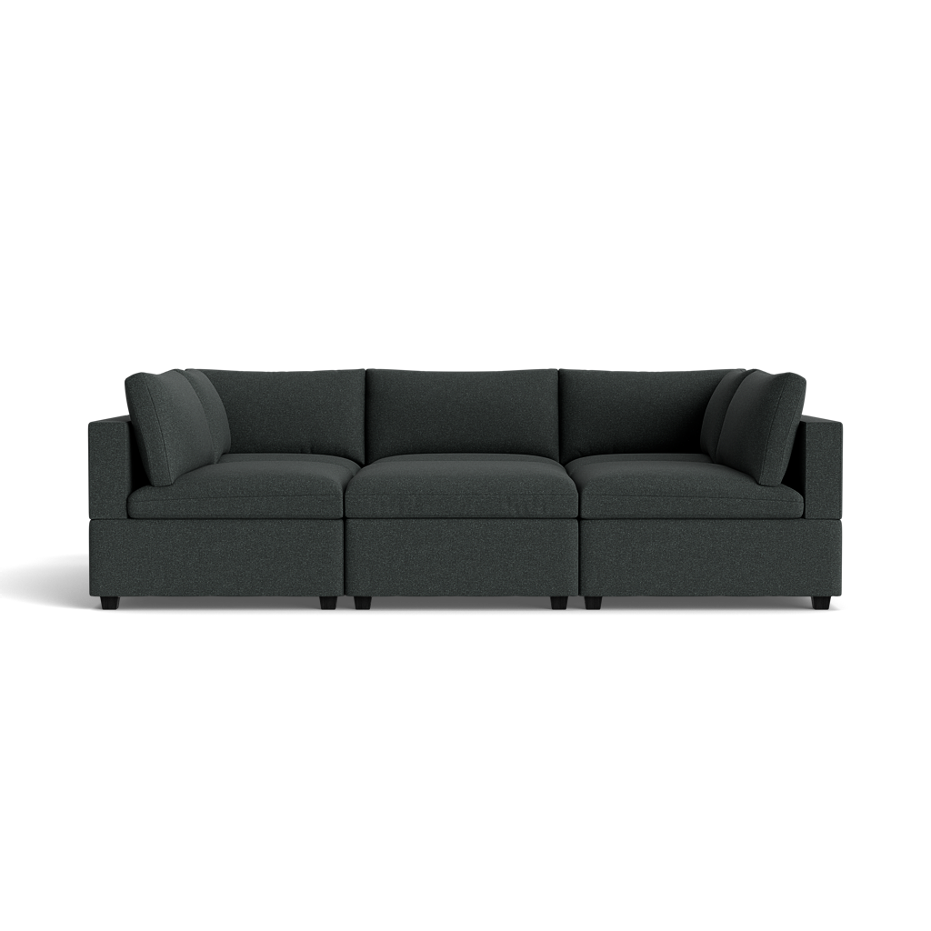 The Kova Box Cushion Pit is a modern dark gray sectional sofa featuring three seat cushions and two corner backrests, isolated on a black background.