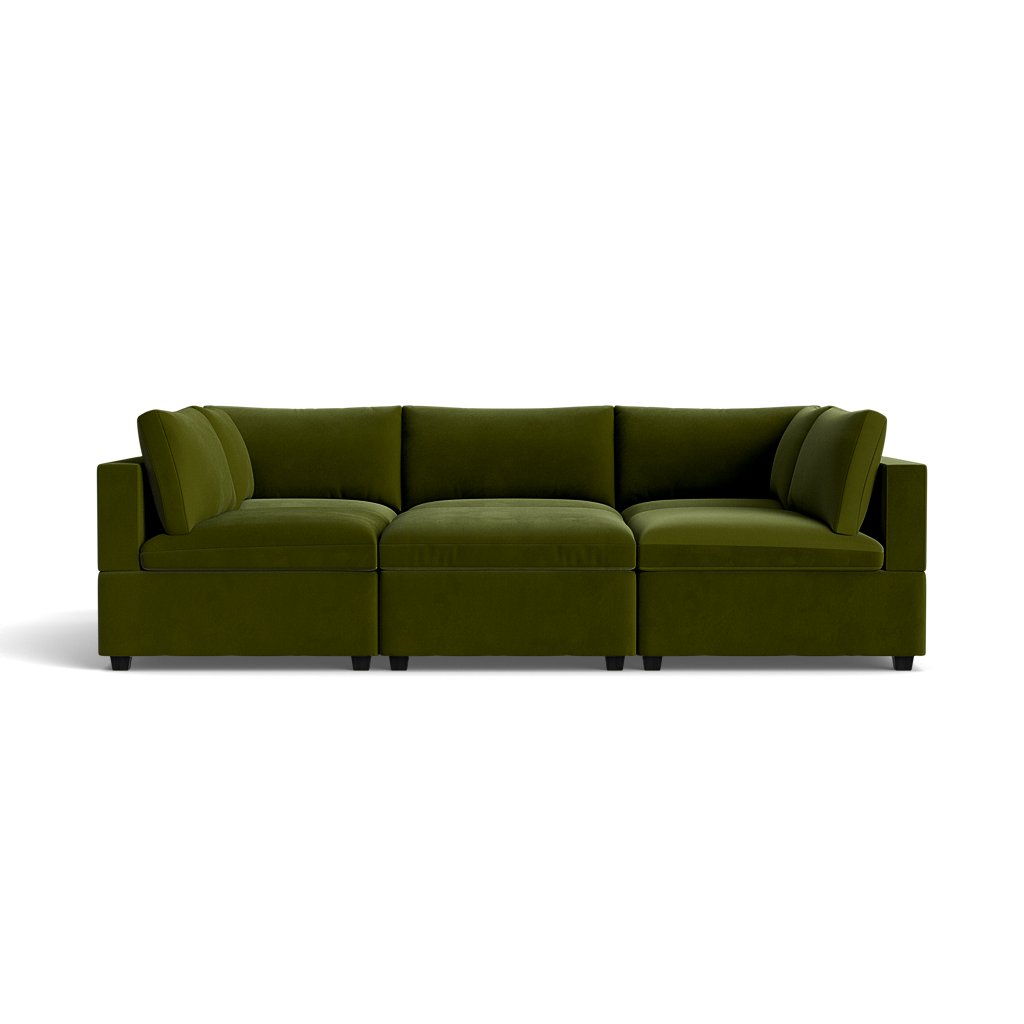 The Kova Box Cushion Pit, a modern sectional sofa in deep green with plush cushions and square arms, is centered against a solid black background.