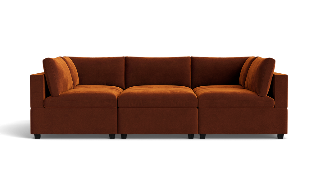 The Kova Box Cushion Pit is a modern sectional sofa in rust color, featuring plush cushions and a low backrest, shown from the front against a plain white background.