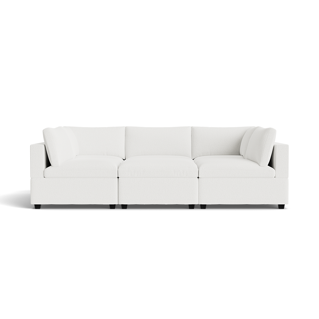 The Kova Box Cushion Pit is a modern white three-seat sectional sofa with plush cushions and low square arms, displayed against a plain black background.