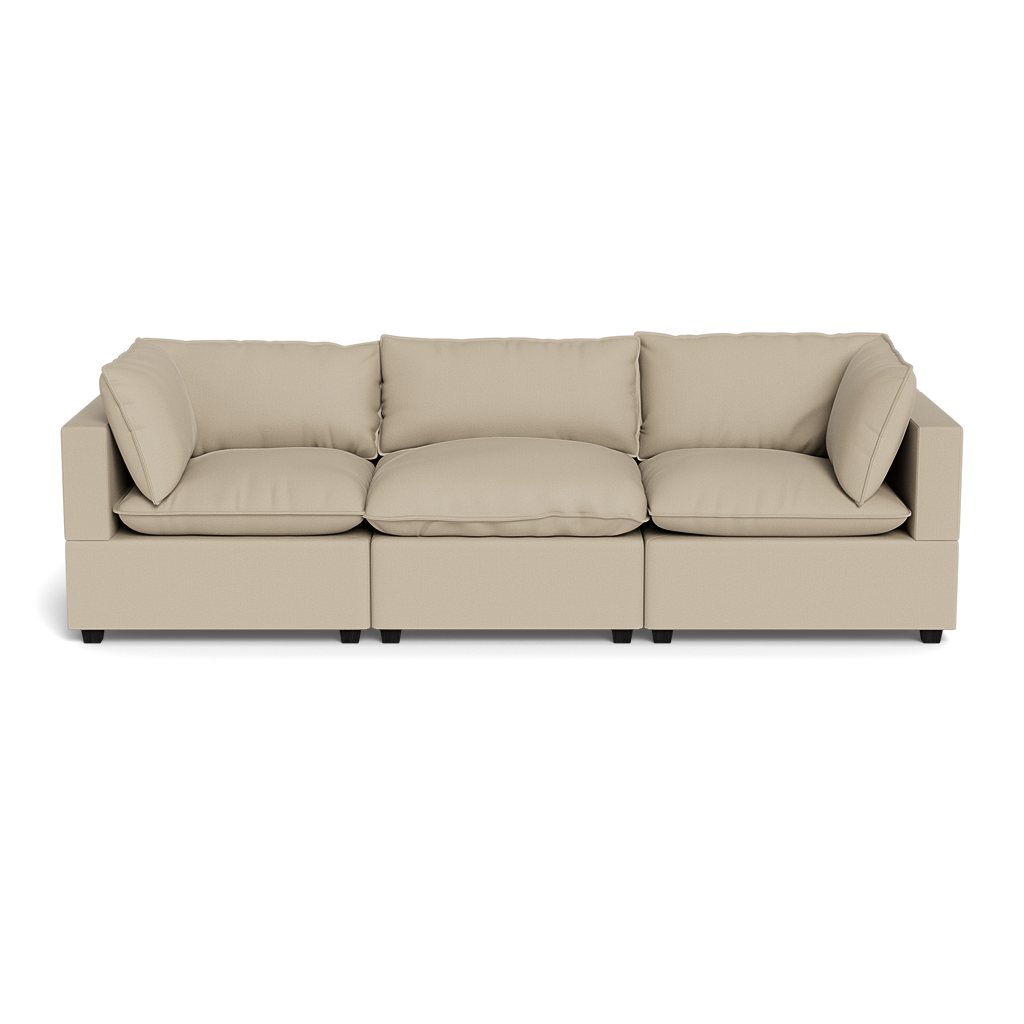 The Kova Pillow Cushion Sofa 122" is a modern beige sectional with three seat cushions, five back cushions, and two armrests, shown from the front against a plain black background.