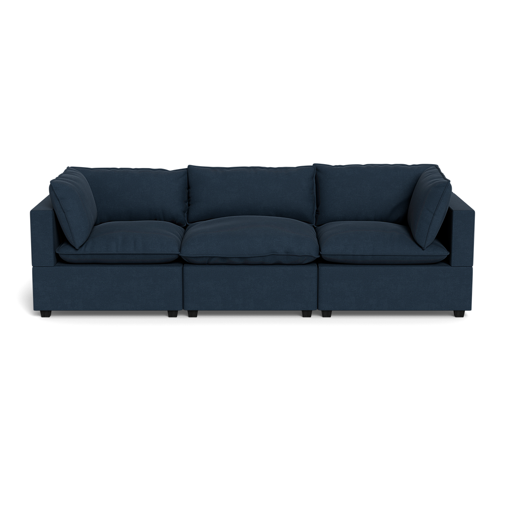 The Kova Pillow Cushion Sofa 122" is a modern dark blue three-seater with square arms and cushioned back and seat, displayed against a plain black background.