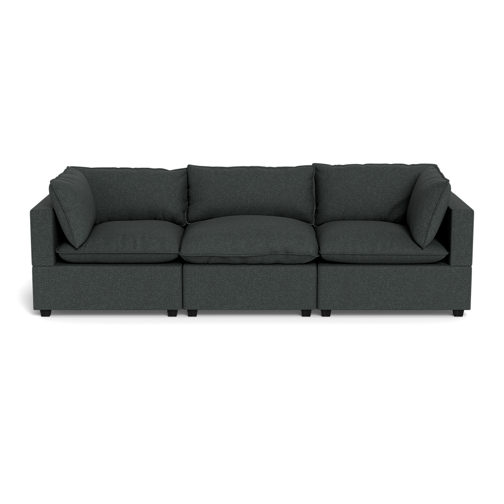 The Kova Pillow Cushion Sofa 122" is a modern, dark gray three-seater with straight armrests and loose back and side cushions, displayed against a black background.