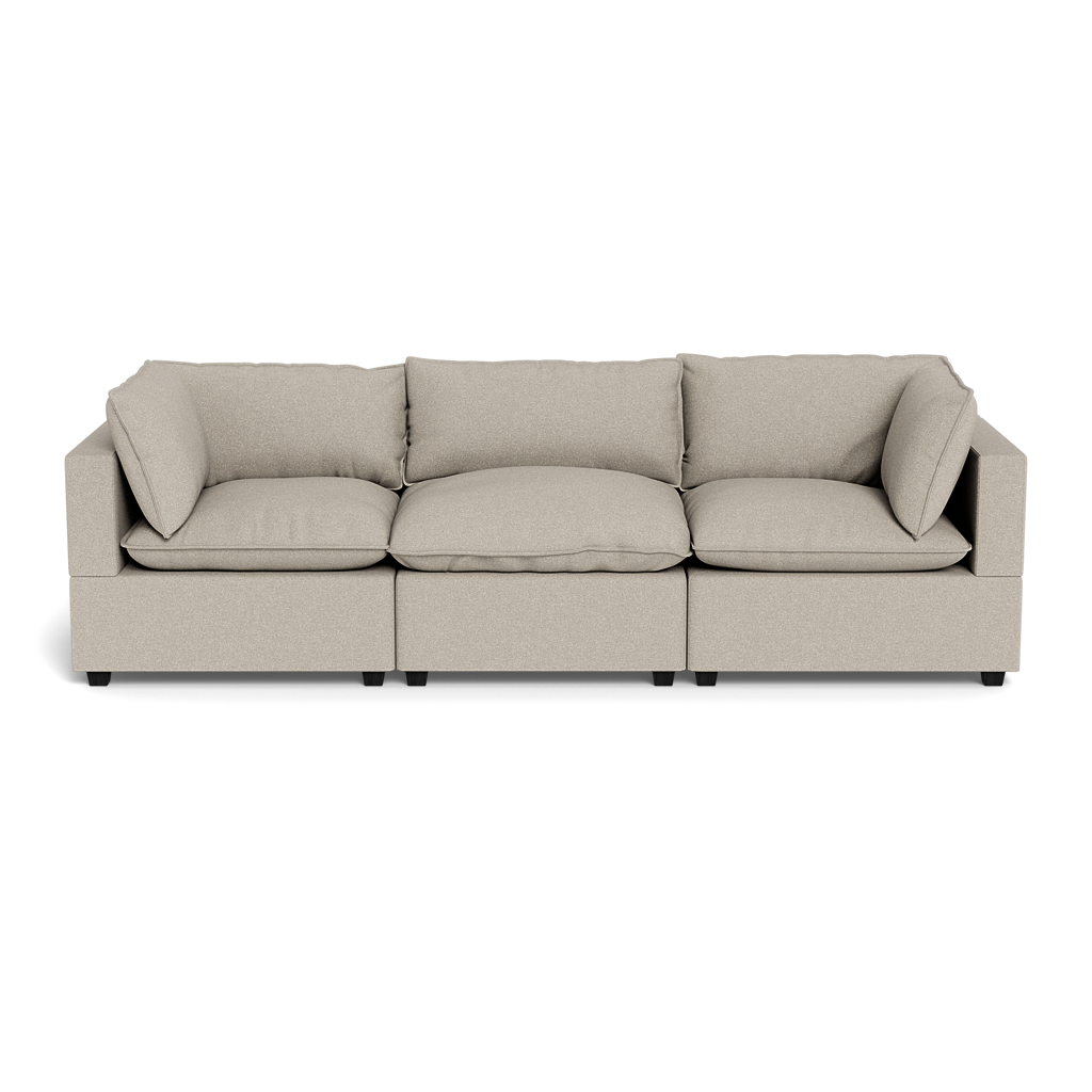 The Kova Pillow Cushion Sofa 122" is a modern beige three-seater with square arms and five matching cushions, shown from the front against a plain black background.
