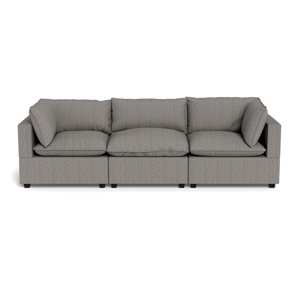 The Kova Pillow Cushion Sofa 122" is a modern, light gray three-seat sofa with square arms and plush back and seat cushions, displayed against a plain black background.