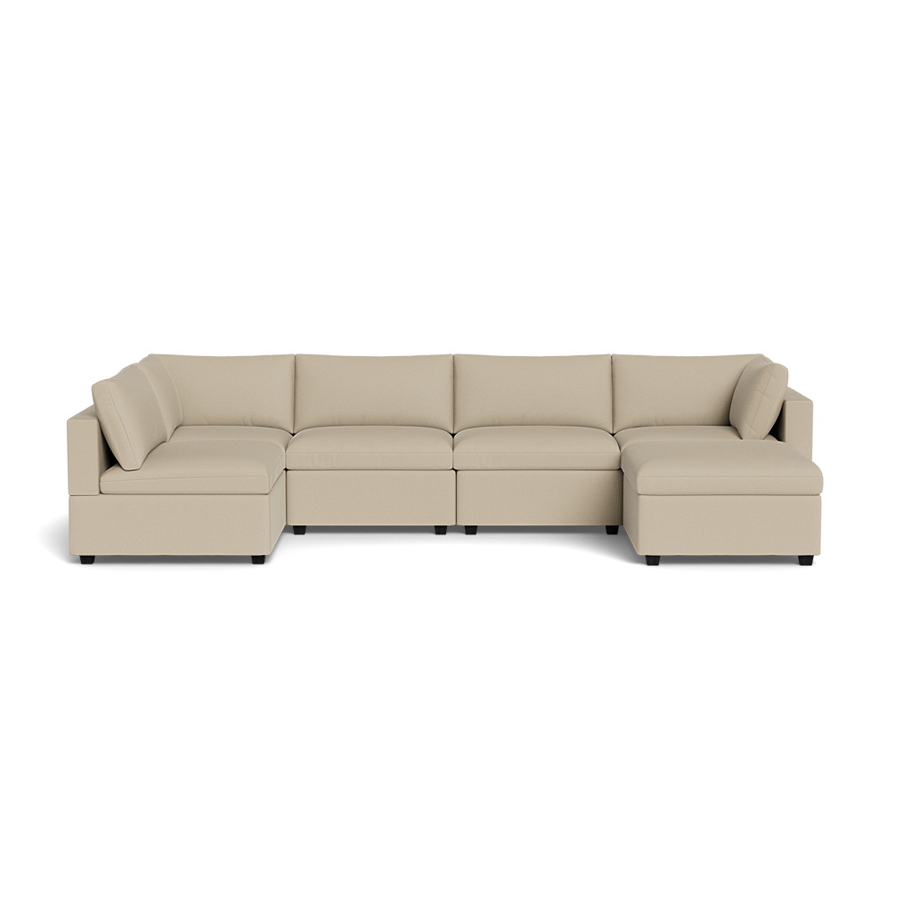 The Kova Box Cushion U-Shape is a spacious, modern sectional in beige fabric with wide cushions and dual chaise lounges, displayed on a plain black background.