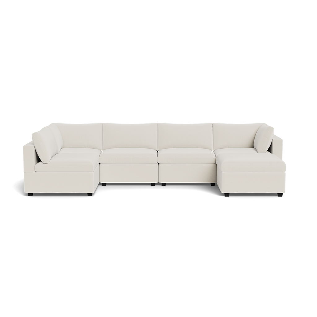 The Kova Box Cushion U-Shape is a modern sectional sofa with light beige upholstery, clean lines, wide seats, low backrests, and plush cushions arranged in a spacious U-shape.