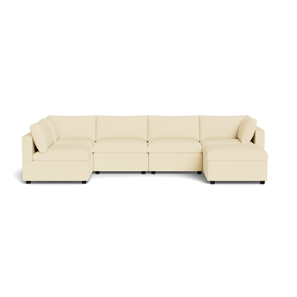 The Kova Box Cushion U-Shape is a large, cream-colored sectional sofa with five seats, low backrests, and a chaise lounge at each end, isolated on a transparent background.