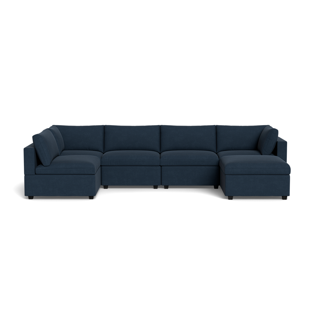 The Kova Box Cushion U-Shape is a large, dark blue sectional sofa with five seats, two corner pieces, wide armrests, and plush cushions, shown from the front against a plain black background.