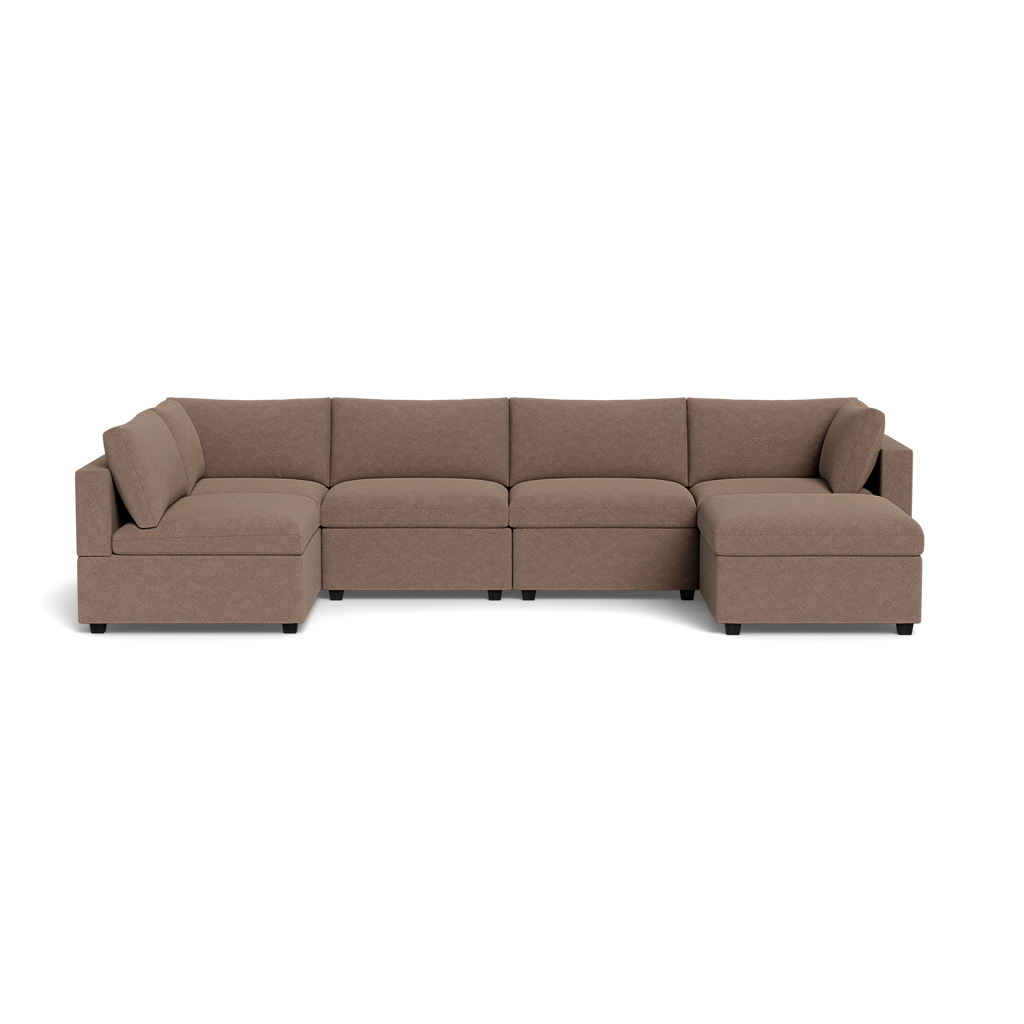 The Kova Box Cushion U-Shape is a spacious, light brown sectional sofa with three seat cushions on the long side and two on each short side, featuring low-profile armrests and backrests in an L-shaped design.