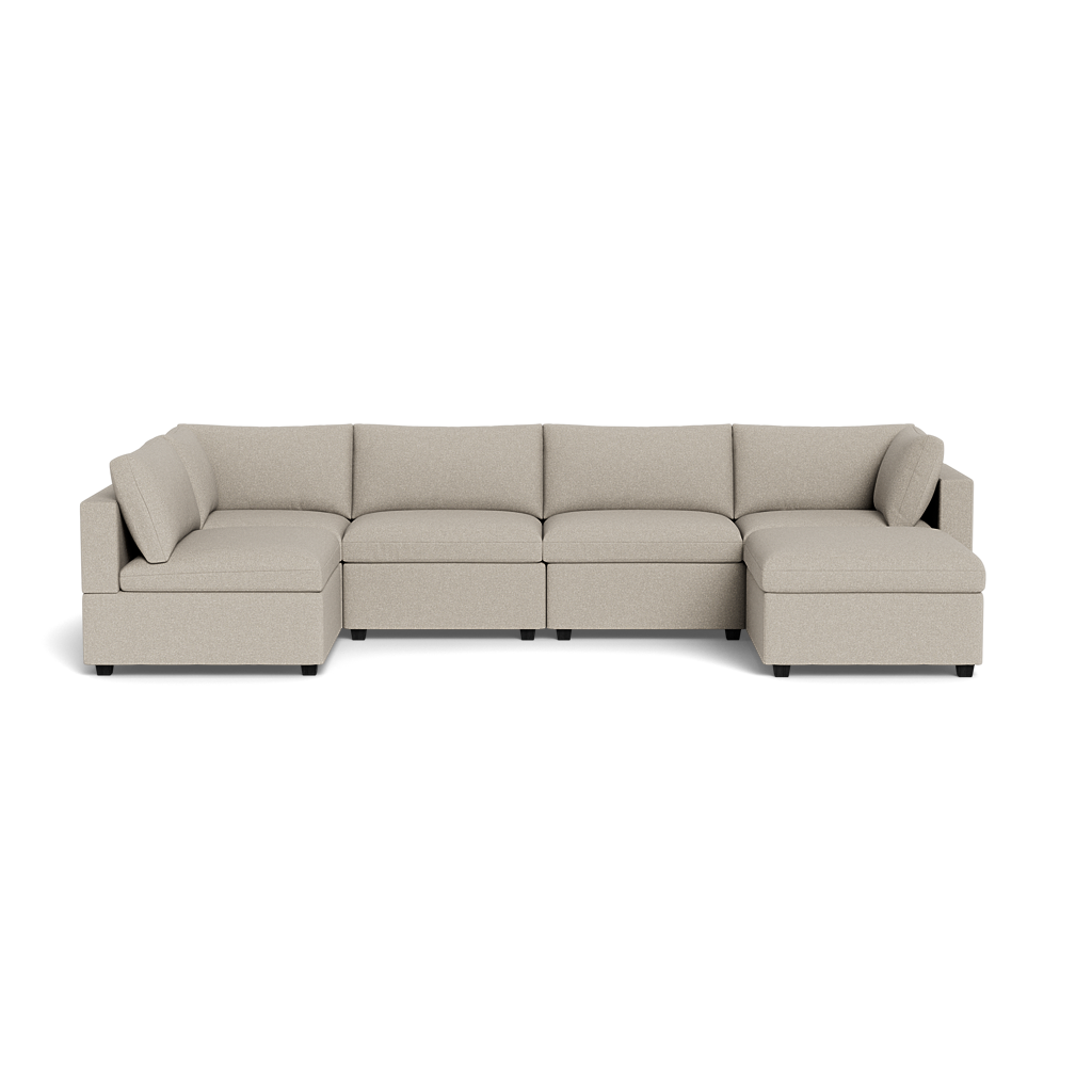 The Kova Box Cushion U-Shape sectional, in beige, features five seat cushions, three backrest cushions, and a right-side chaise lounge, set against a plain black background.