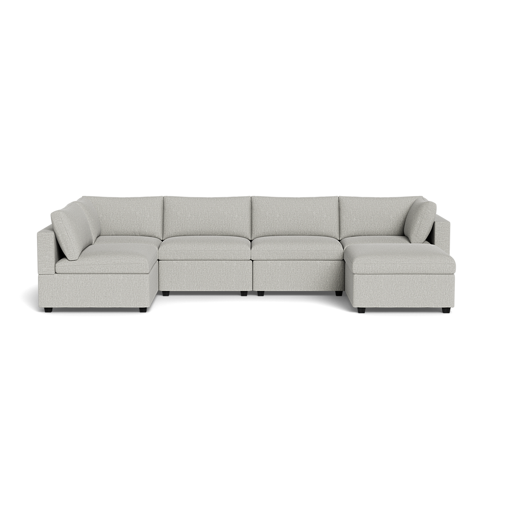 The Kova Box Cushion U-Shape is a large, light gray sectional sofa with five seat cushions and matching back and side cushions, arranged in a U-shape on a black background.