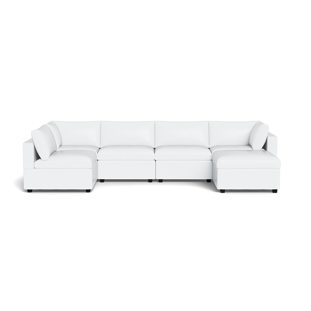 The Kova Box Cushion U-Shape is a large, modern white sectional sofa featuring chaise lounges on both ends and multiple back cushions, shown from the front against a plain black background.
