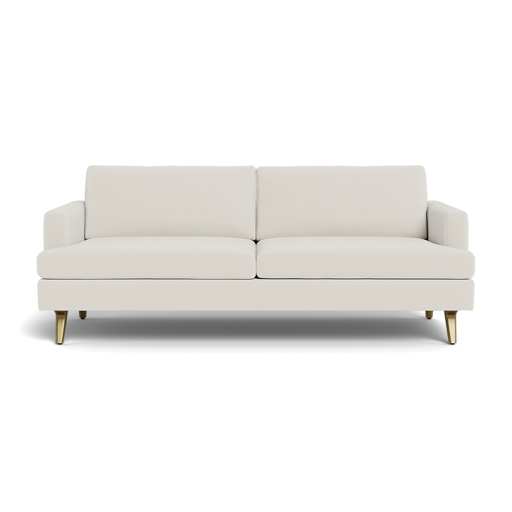 The Lido Sofa 75" is a modern, light beige sofa with two seat and backrest cushions, low armrests, and four angled gold legs, displayed on a plain black background.