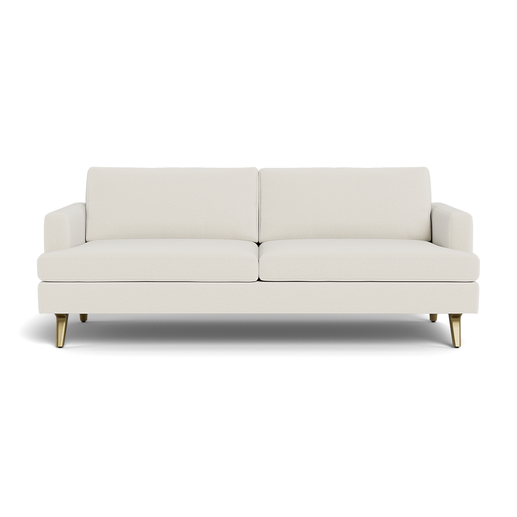 The Lido Sofa 75" is a modern, cream-colored piece featuring straight lines, two seat and back cushions, slim armrests, and four wooden legs with gold accents, shown against a plain black background.