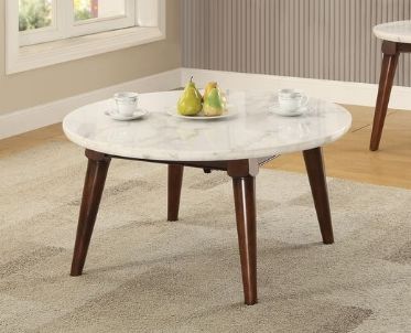 The Gasha Coffee Table in white marble with walnut legs stands on a light carpet in a bright room, topped with two cups and saucers and a small plate holding three pears.