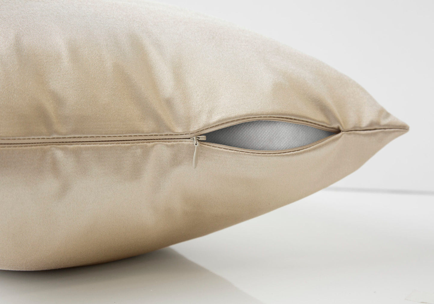 A close-up of a beige Square Decorative Throw Pillow with insert included, featuring a partially open zipper that shows the white hypoallergenic inner lining and filling. The background is plain white for a modern look.