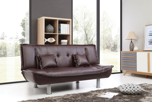 A modern living room featuring the Lionel - Sofa Bed in dark brown leather, two matching cushions, a shaggy gray rug, a patterned pillow, wooden shelf, sideboard, lamp, and large windows overlooking trees.