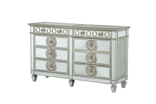 The Varian - Mirrored Dresser - Silver features two columns of drawers adorned with circular metallic accents. Its reflective surface and tapered legs create a modern, elegant look.