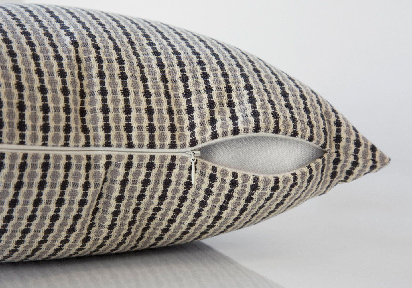 A close-up of a Square Decorative Throw Pillow, featuring a black and beige checkered pattern and a partially open white zipper revealing the hypoallergenic insert. The background is plain and light-colored. Insert included.