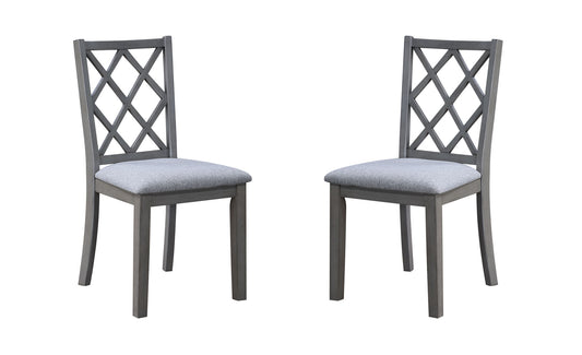 Two Carlisle Cross Back Side Dining Chairs in gray wood with cushioned seats, featuring a crisscross backrest design, are positioned facing each other against a white background.
