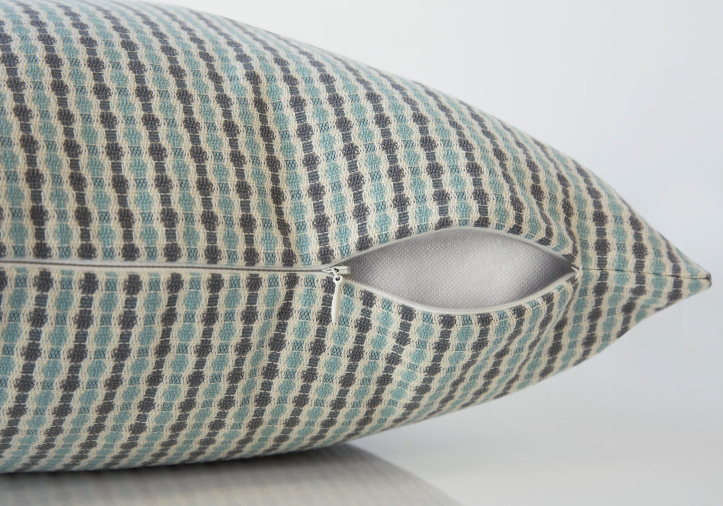 A close-up of a Square Decorative Throw Pillow with a blue, gray, and beige checkered pattern and a partially open white zipper, revealing the hypoallergenic insert included.