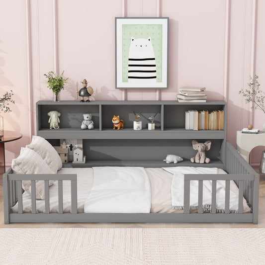 A Floor Bed With Side Bookcase, Shelves, and Guardrails in gray stands against a pink wall. Plush toys, books, and decor fill the shelves; framed cat art hangs above. Pillows, plants, and a lamp complete the cozy space.