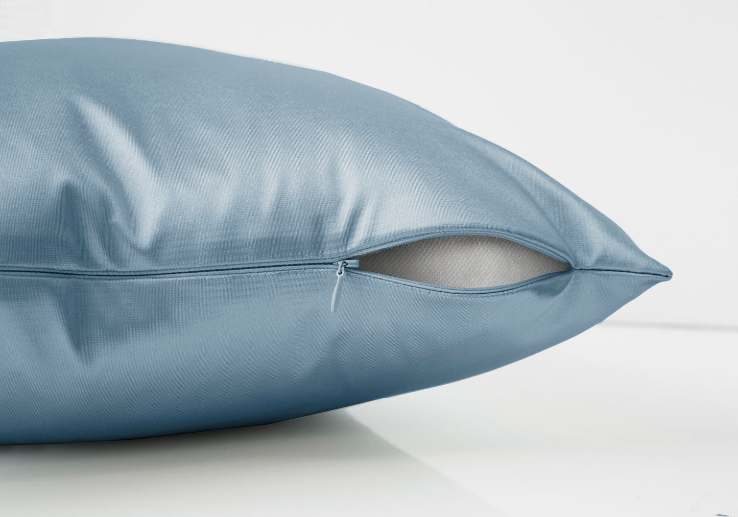 A close-up of our modern blue decorative square throw pillow with insert included, featuring a visible partially open zipper revealing the hypoallergenic white inner lining. The pillow rests on a white surface against a plain white background.