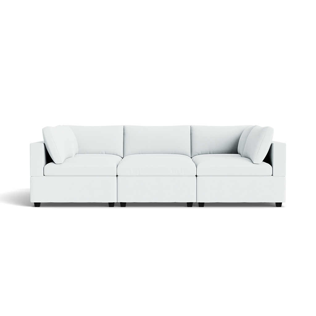 The Kova Box Cushion Pit, a modern white sectional sofa with three seats and four matching cushions, is shown from the front against a plain background.