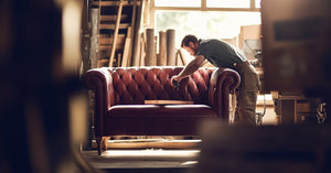 A beautiful woman sitting on a couch made of all natural wood