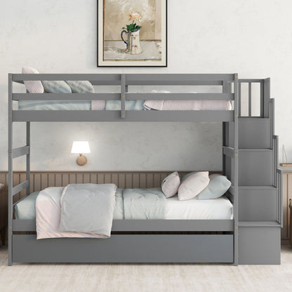 The Twin Over Twin Bunk Beds with Trundle and Stairway Storage features a modern gray design, right-side staircase, and fits perfectly in a cozy bedroom with neatly made beds, wall lamp, and framed artwork above the headboard.