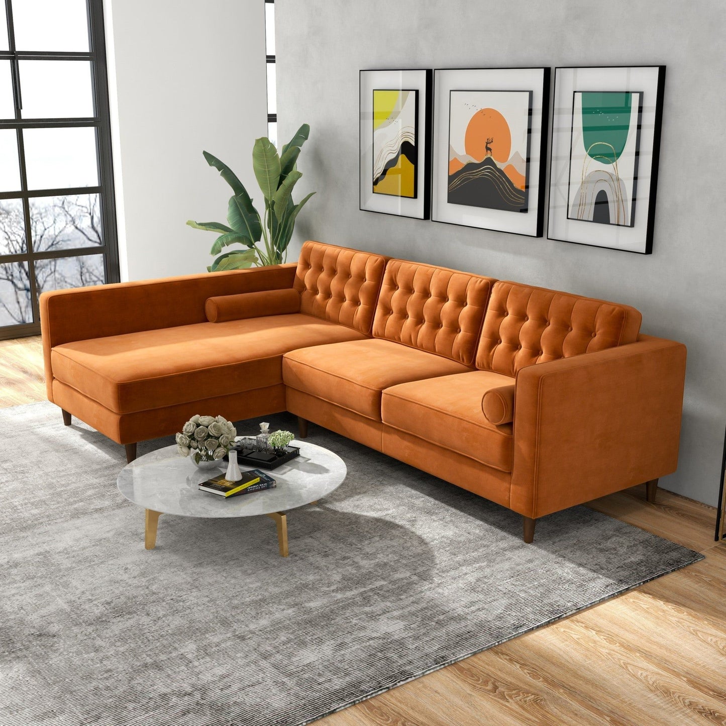 A modern living room features the Christian Mid-Century Modern Design Sectional Sofa in orange, a round marble coffee table, a large gray rug, a green plant, and three colorful abstract artworks on a gray wall with large windows.