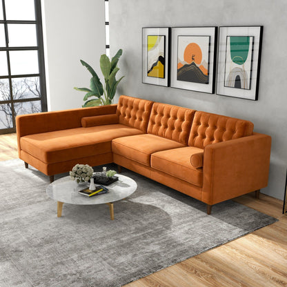 A modern living room features the Christian Mid-Century Modern Design Sectional Sofa in orange, a round marble coffee table, a large gray rug, a green plant, and three colorful abstract artworks on a gray wall with large windows.