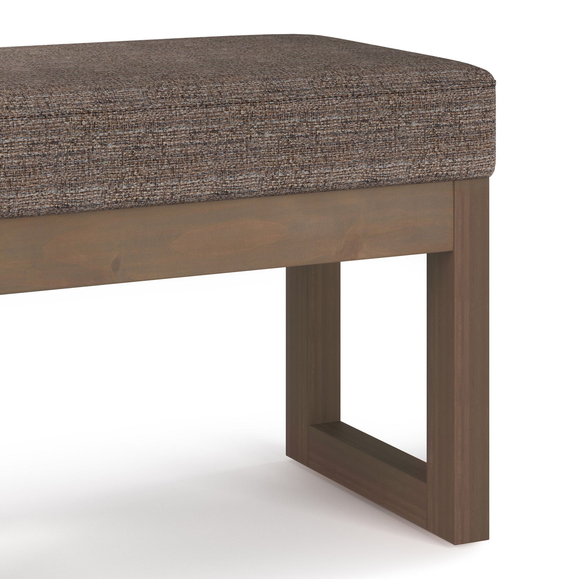 A close-up of the Milltown Upholstered Ottoman Bench shows its brown fabric cushion and simple wooden base with clean lines and rectangular legs, set against a plain white background.