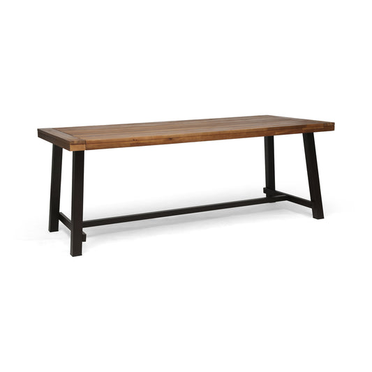 The Equilibrium Outdoor Dining Table features a wooden frame and slat top with a simple, modern design, perfect for outdoor dining.