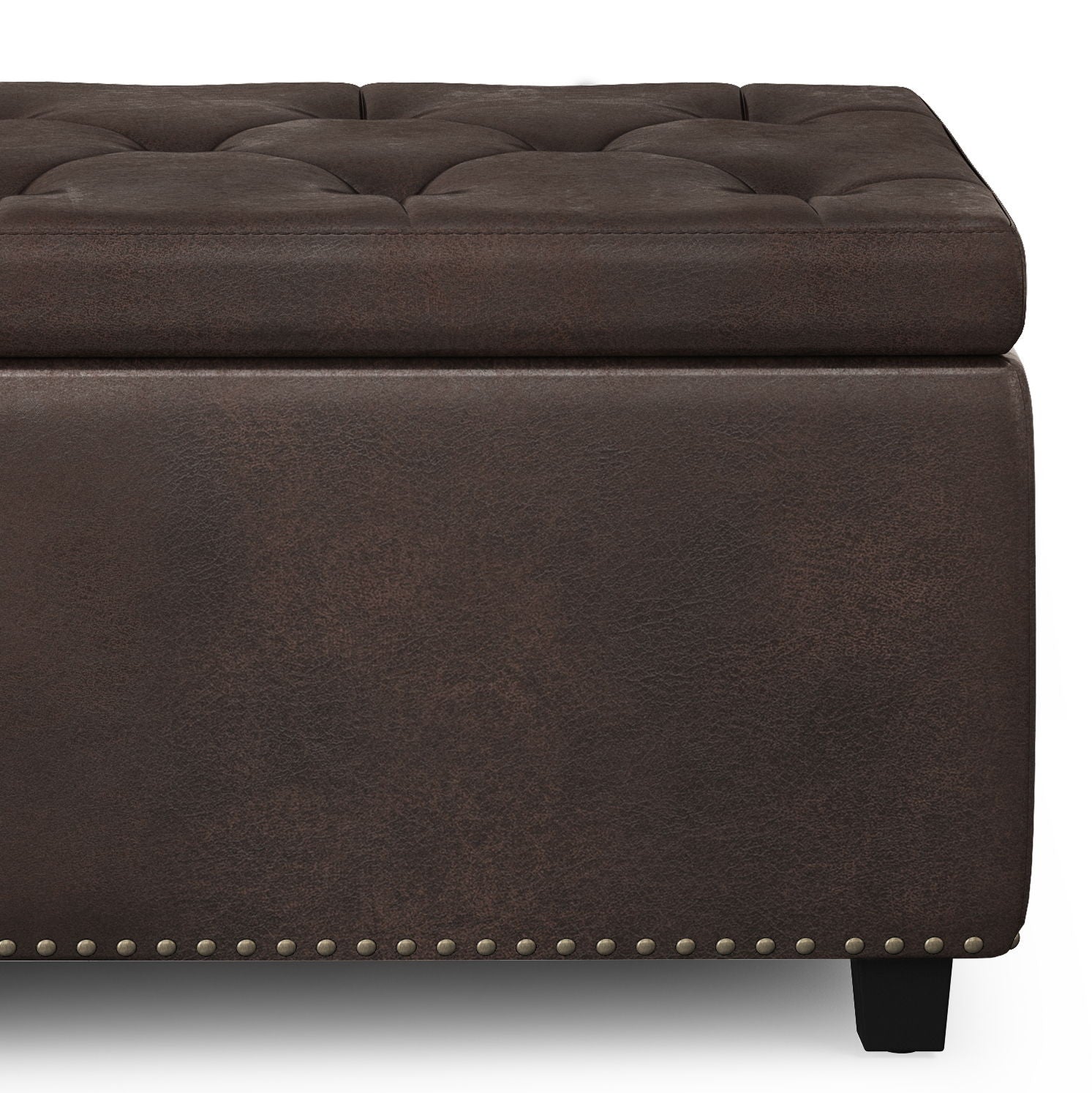Close-up of the Hamilton Upholstered Storage Ottoman featuring dark brown tufted leather, a cushioned top, decorative nailhead trim at the base, and short black legs.