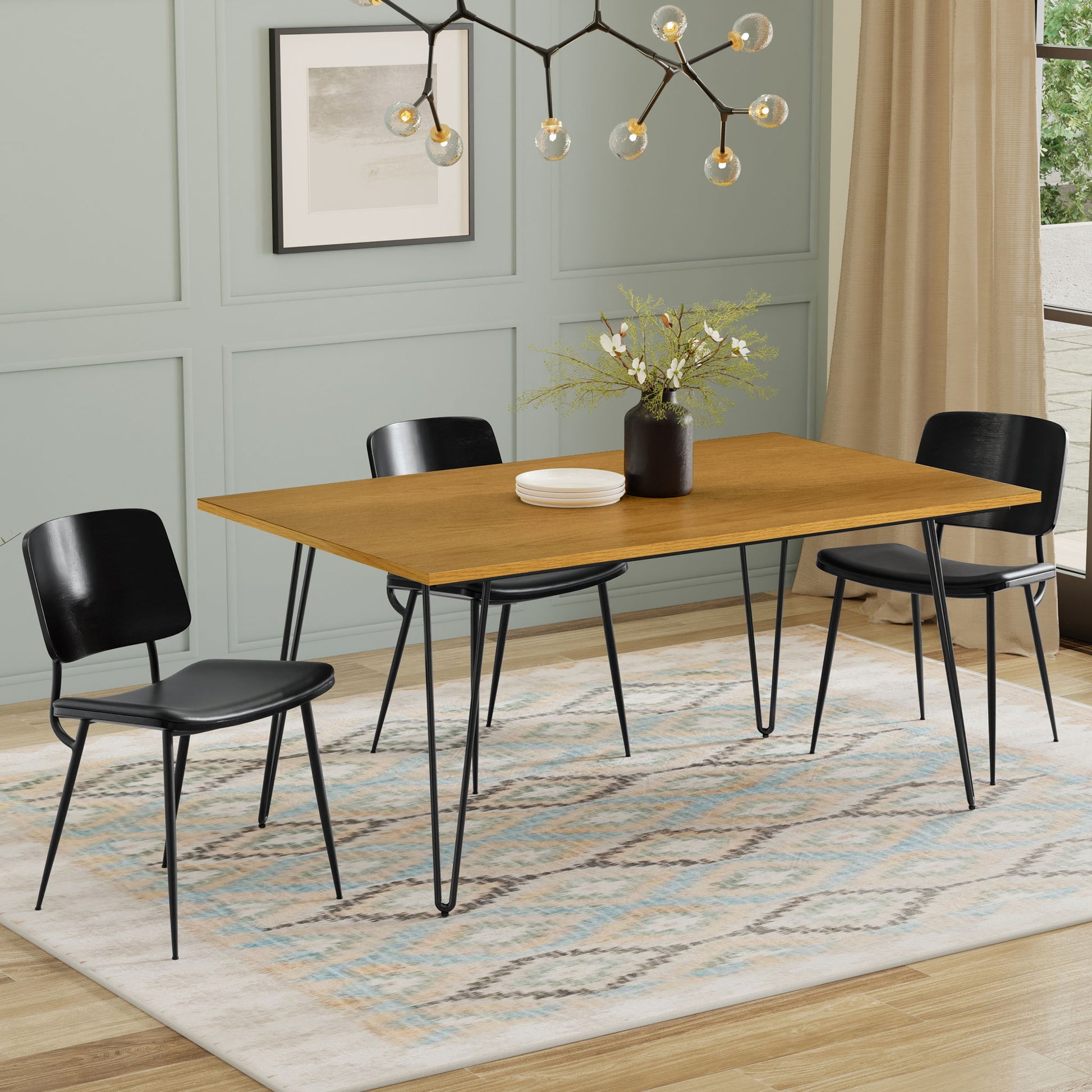 A modern dining room featuring the Hunter - Square Tabletop Dining Table, three black metal-leg chairs, a geometric chandelier, a beige patterned rug, a potted plant centerpiece, framed wall art, and beige curtains by the window.