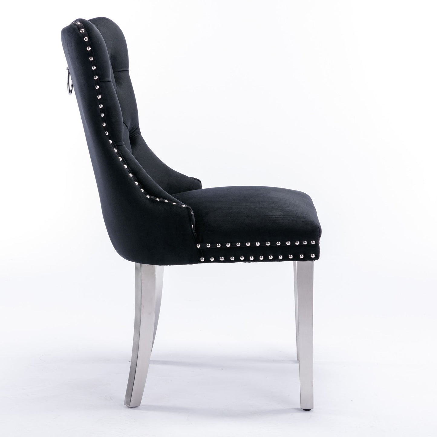 Side view of the Nikki modern high-end tufted velvet dining chair with chrome stainless steel legs and nailhead trim, upholstered in black, set against a plain white background. Set of 2.