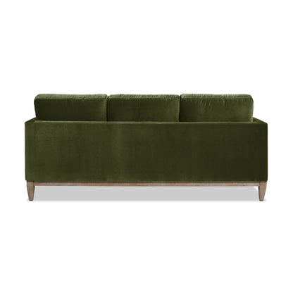The Knox - Modern Farmhouse Sofa in green velvet features three back cushions and wooden legs, displayed from the back against a white background.
