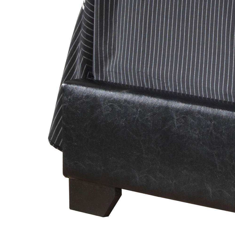 Close-up of the corner of the Elegant Platform Bed For Relaxed Spaces, featuring black upholstery and a gray and white pinstriped bedspread draped over the edge.