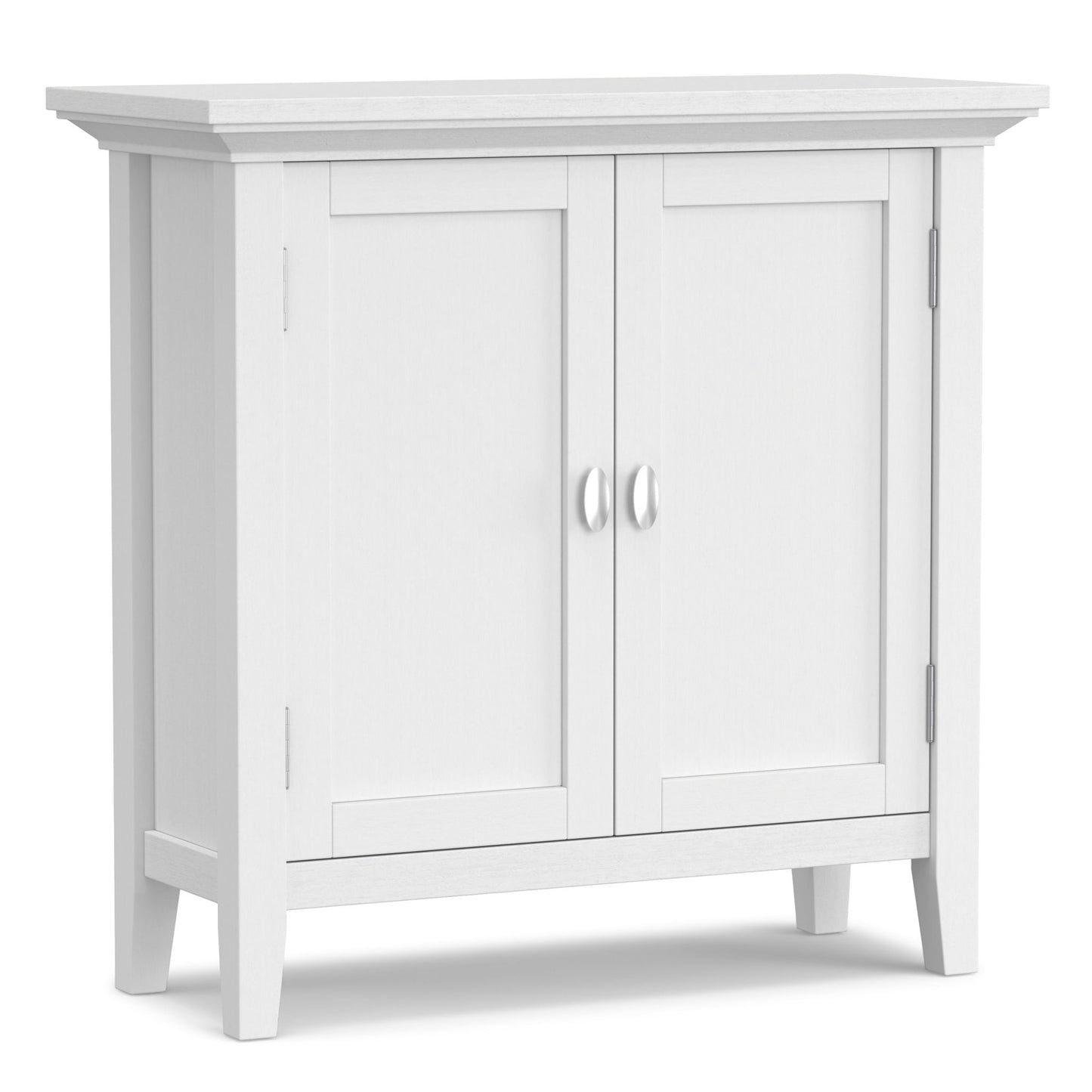 The Redmond Handcrafted Low Storage Cabinet features a white wooden finish, two paneled doors with silver handles, and four short legs, shown against a plain background.