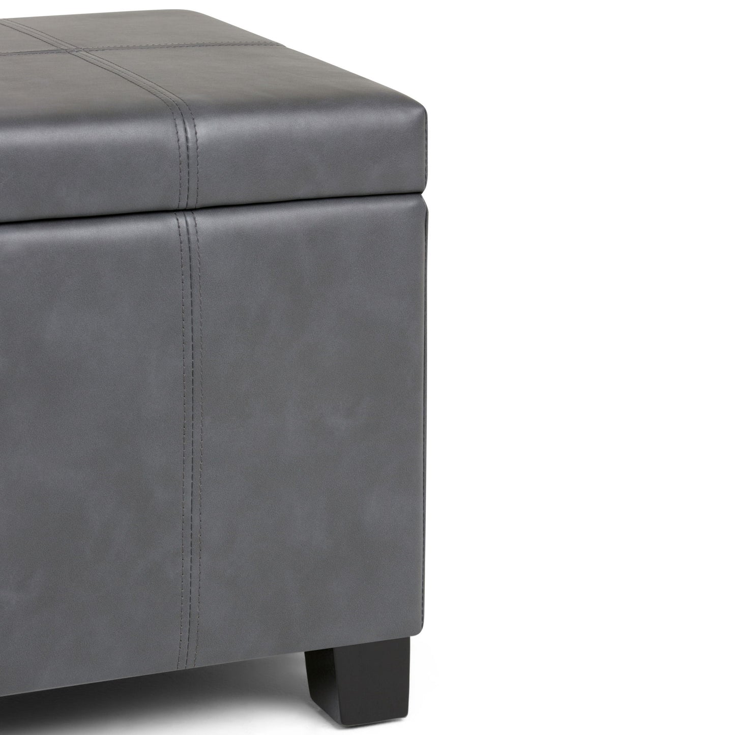 A close-up of the Dover - Upholstered Storage Ottoman Bench, showcasing its modern gray leather or faux leather upholstery with visible stitching and dark wooden legs.