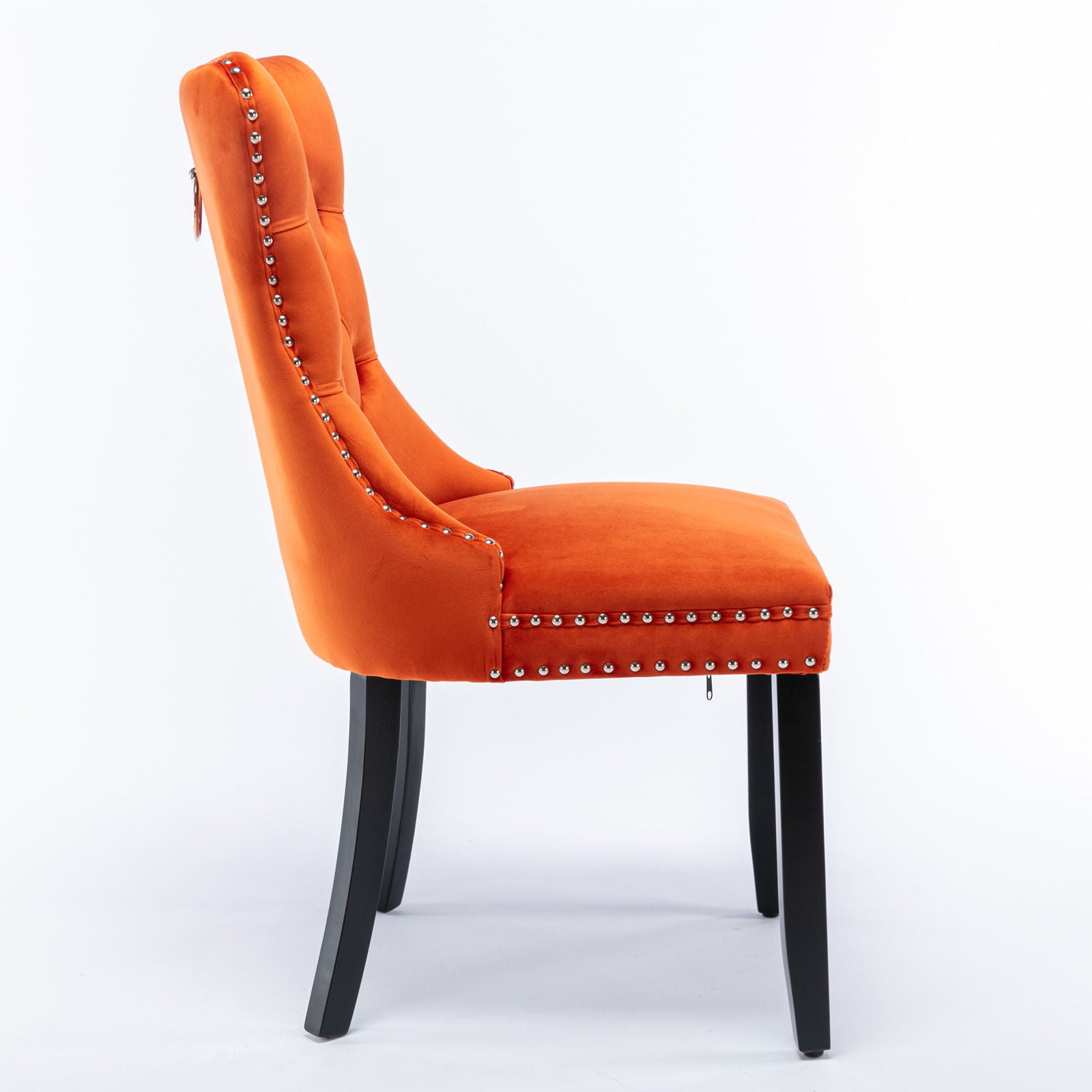 A side view of the Nikki contemporary velvet upholstered dining chair (set of 2) with silver nailhead trim, tufted backrest, and black wood legs against a plain white background.