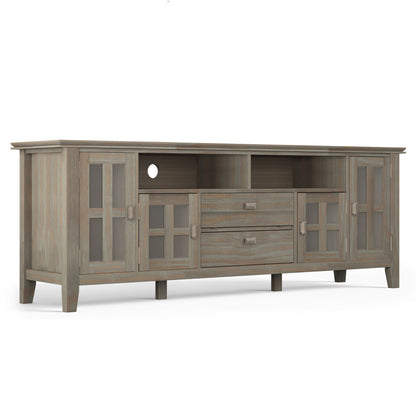 The Artisan TV Media Stand features a weathered gray wood finish, two glass-door cabinets on each side, two central drawers, and two open shelves above the drawers.