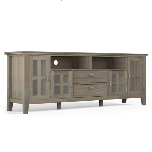 The Artisan TV Media Stand features a weathered gray wood finish, two glass-door cabinets on each side, two central drawers, and two open shelves above the drawers.