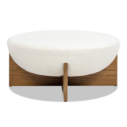 The Bali - Round Upholstered Ottoman features a modern design with a white, textured cushion and a wooden base with intersecting support panels.