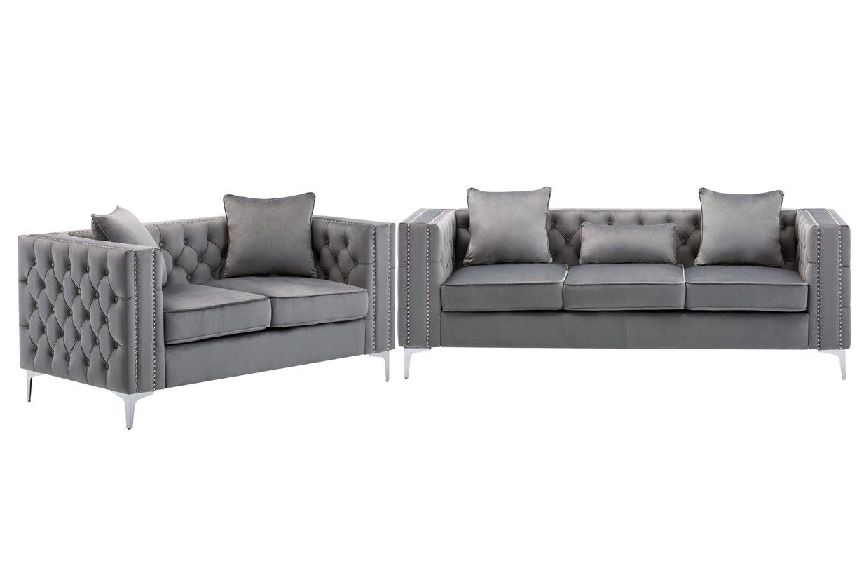 The Lorreto Velvet Fabric Living Room Set includes two modern gray sofas with tufted backs and arms, silver nailhead trim, metal legs, matching cushions, and decorative pillows for extra comfort.