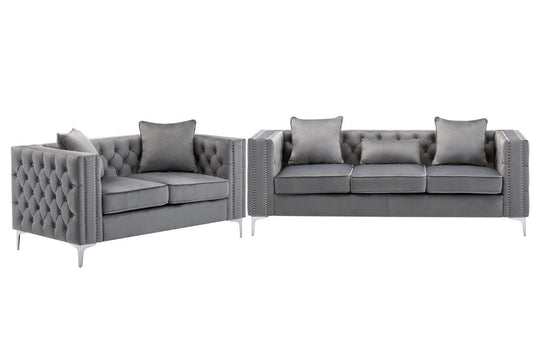 The Lorreto Velvet Fabric Living Room Set includes two modern gray sofas with tufted backs and arms, silver nailhead trim, metal legs, matching cushions, and decorative pillows for extra comfort.